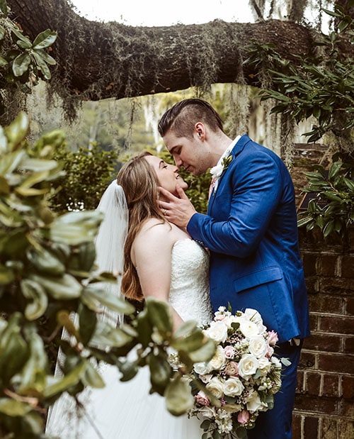 wedding photographer - a newlywed couple kiss underneath a tree