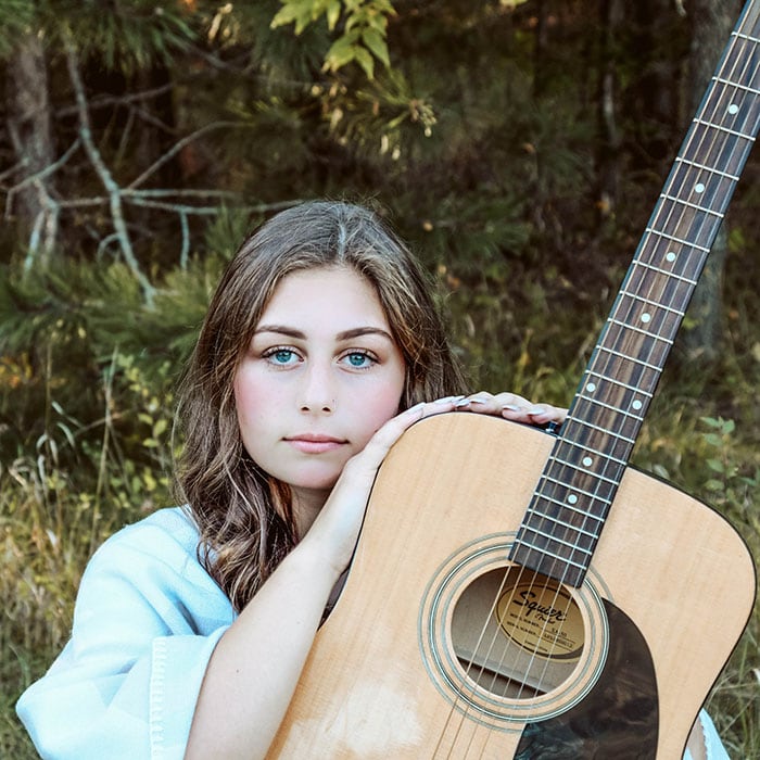 Branding photography - a young woman sits with her acoustic guitar