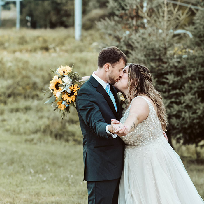 Wedding photographer - a newlywed couple kiss outside