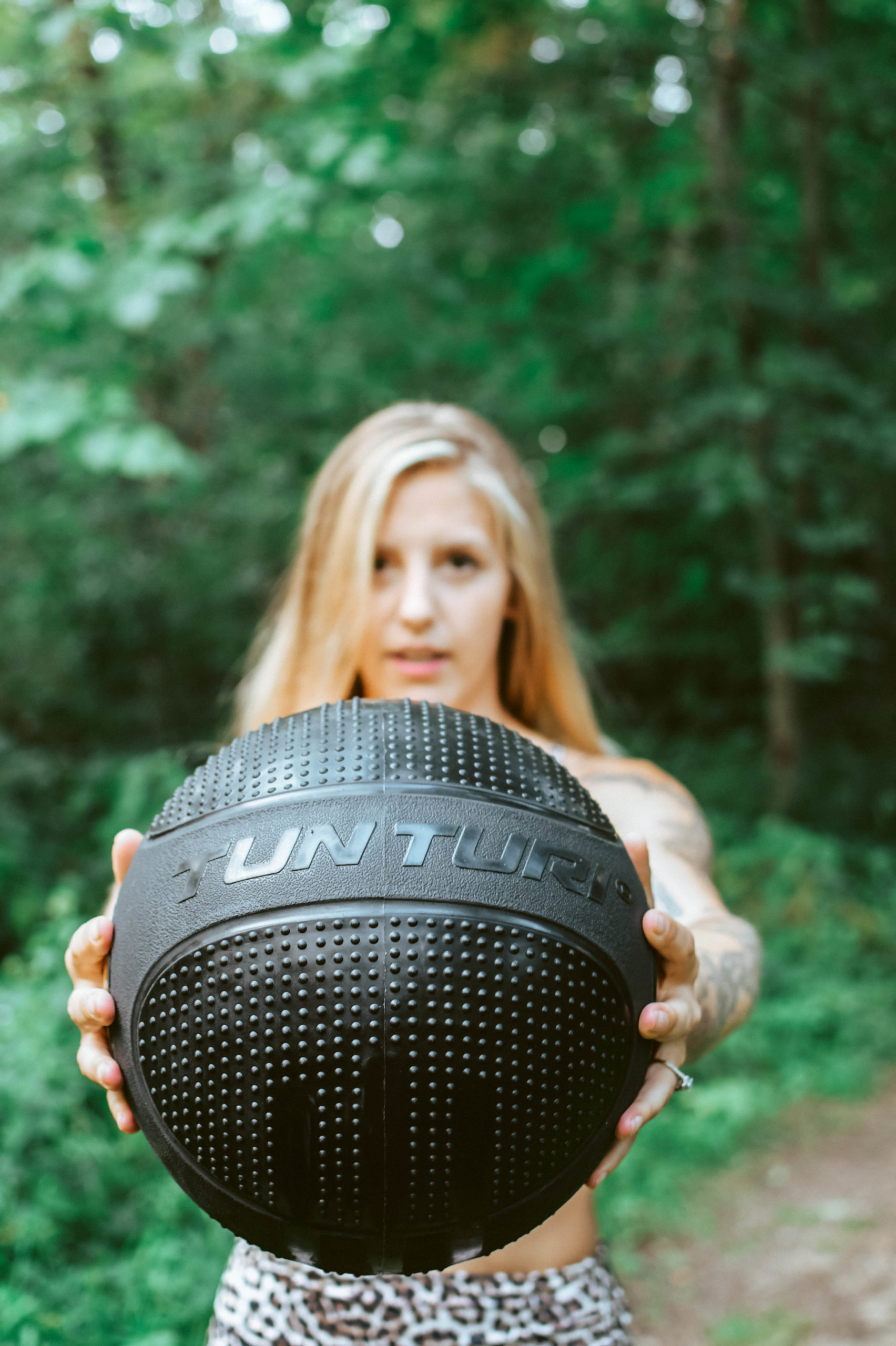 Branding photography - a fitness instructor holds a gym ball towards the camera
