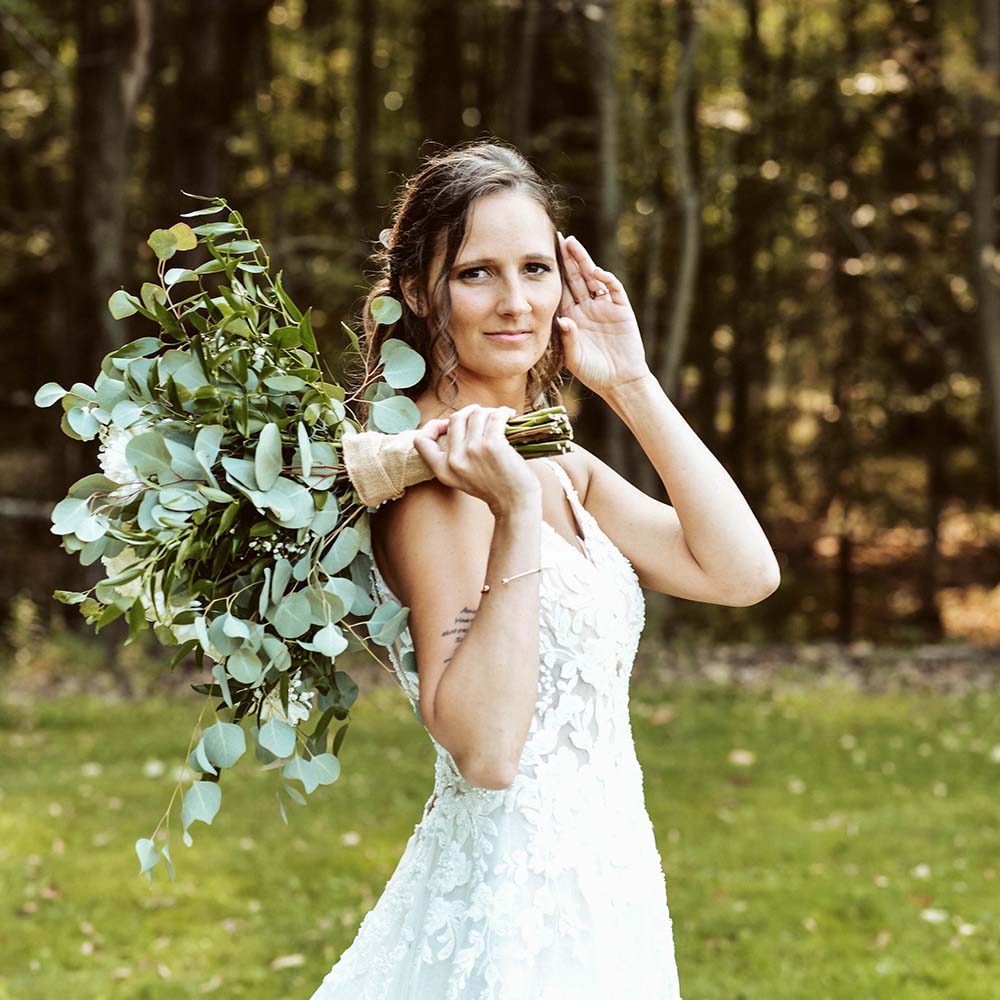 Wedding photography - a bride poses, holding flowers over her shoulder