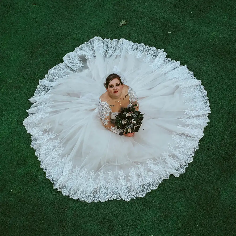 A bride looks up at the camera. Photographed by drone.