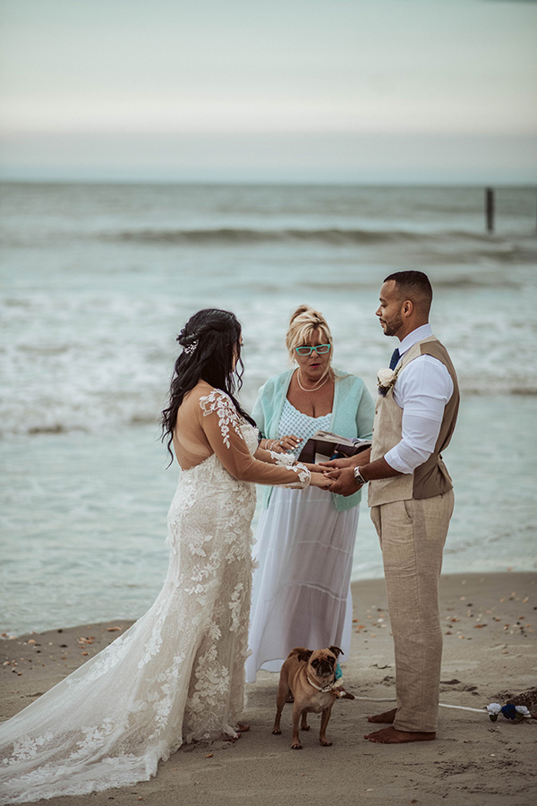 a bridge and groom say their vows during a beach elopement