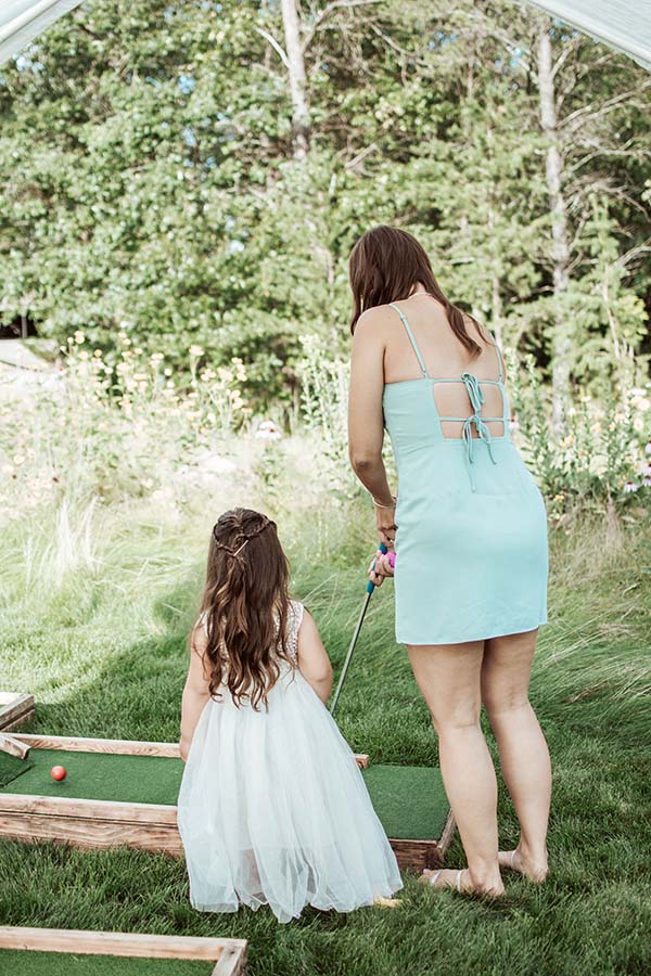 a lady and young girl play mini golf at a wedding reception in Wisconsin