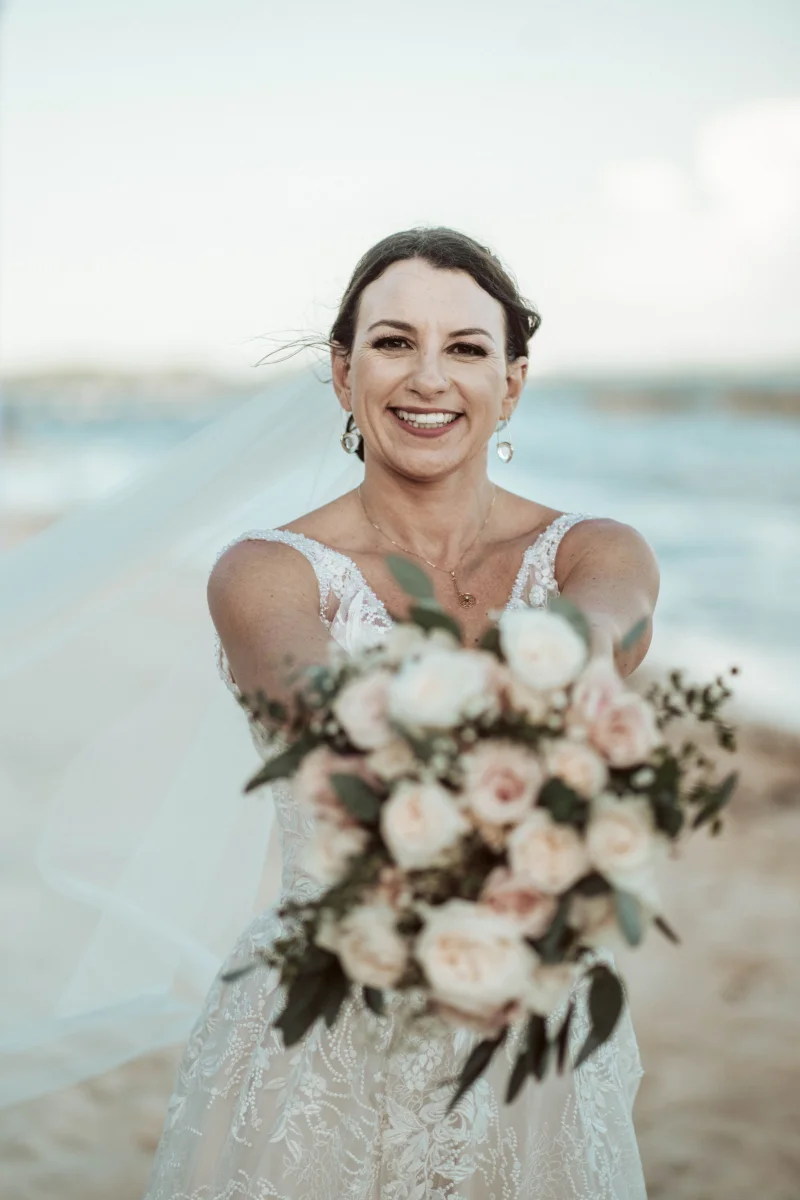Bride holds her flowers out during her elopement to Mexico