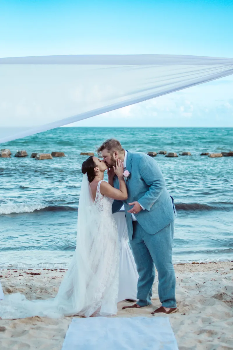 Newly married couple kiss on the beach