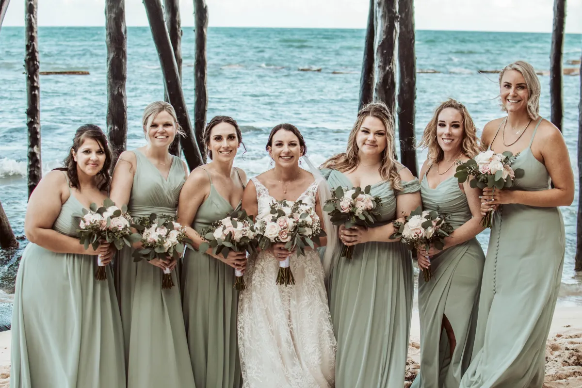 The bride with her bridesmaids wearing green dresses