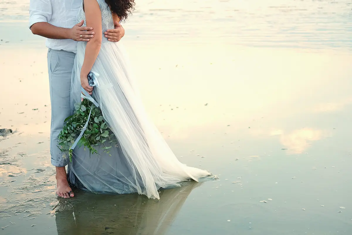 A couple embrace on the beach during their elopement