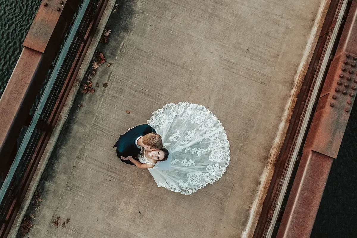 An aerial photograph of a bride and groom, taken using a drone