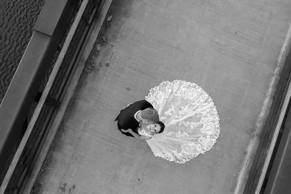 an aerial photograph of a bridge and groom, taken with a drone on their wedding day