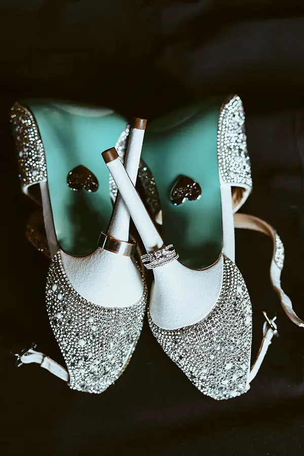 a close up of a bride's sparkly shoes, showing the heel and a green sole