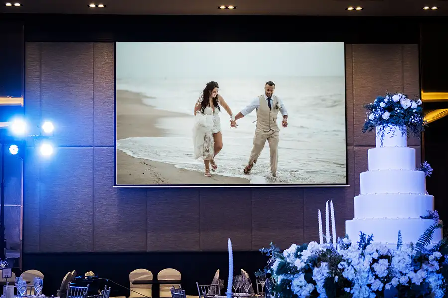 a wedding photograph displayed on a large screen by a projector