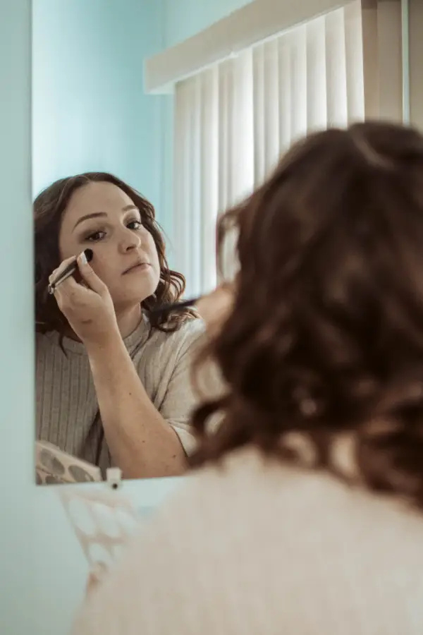 A bride applying her makeup before the elopement ceremony