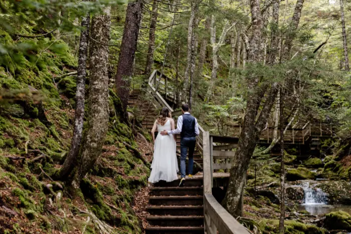 A bride and groom walk up the stairs in a park in New Brunswick, Canada