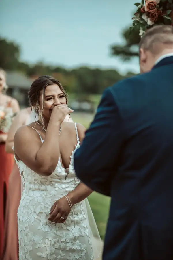 The bride is overcome with emotion as the groom reads his vows to her.