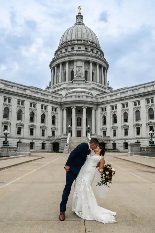 A newly wed couple kiss in front of the Capitol Building
